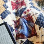 patchwork quilt laid over legs while reading in a chair