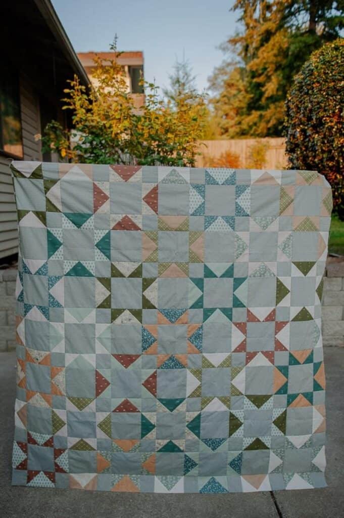 Benedict Quilt a scrappy flying geese quilt in blue, green, and brown fabrics