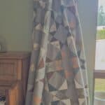 Benedict quilt a scrappy flying geese quilt hanging from a quilt ladder