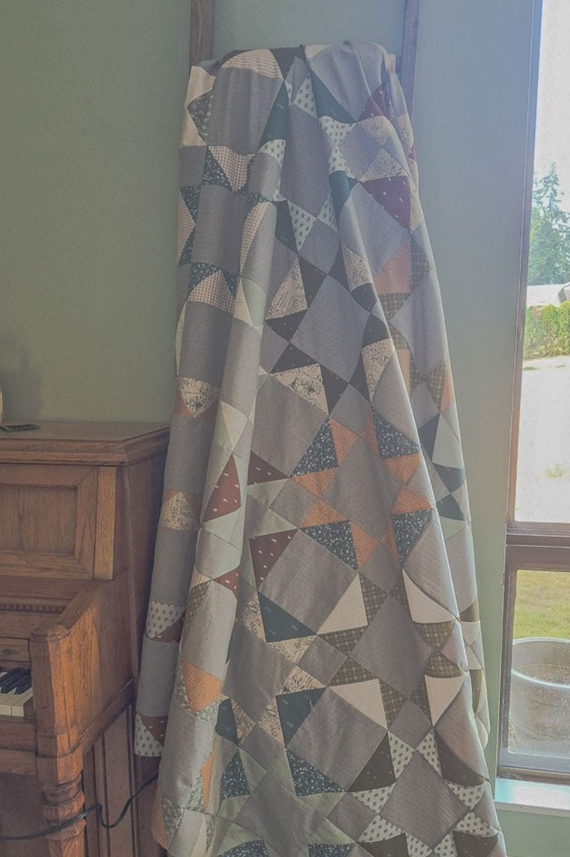 Benedict quilt a scrappy flying geese quilt hanging from a quilt ladder