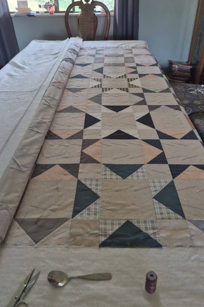 Benedict quilt laid out on a table for thread basting